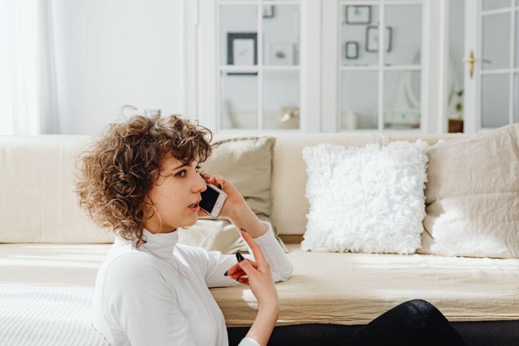 A woman at home talking to a doctor on her mobile phone