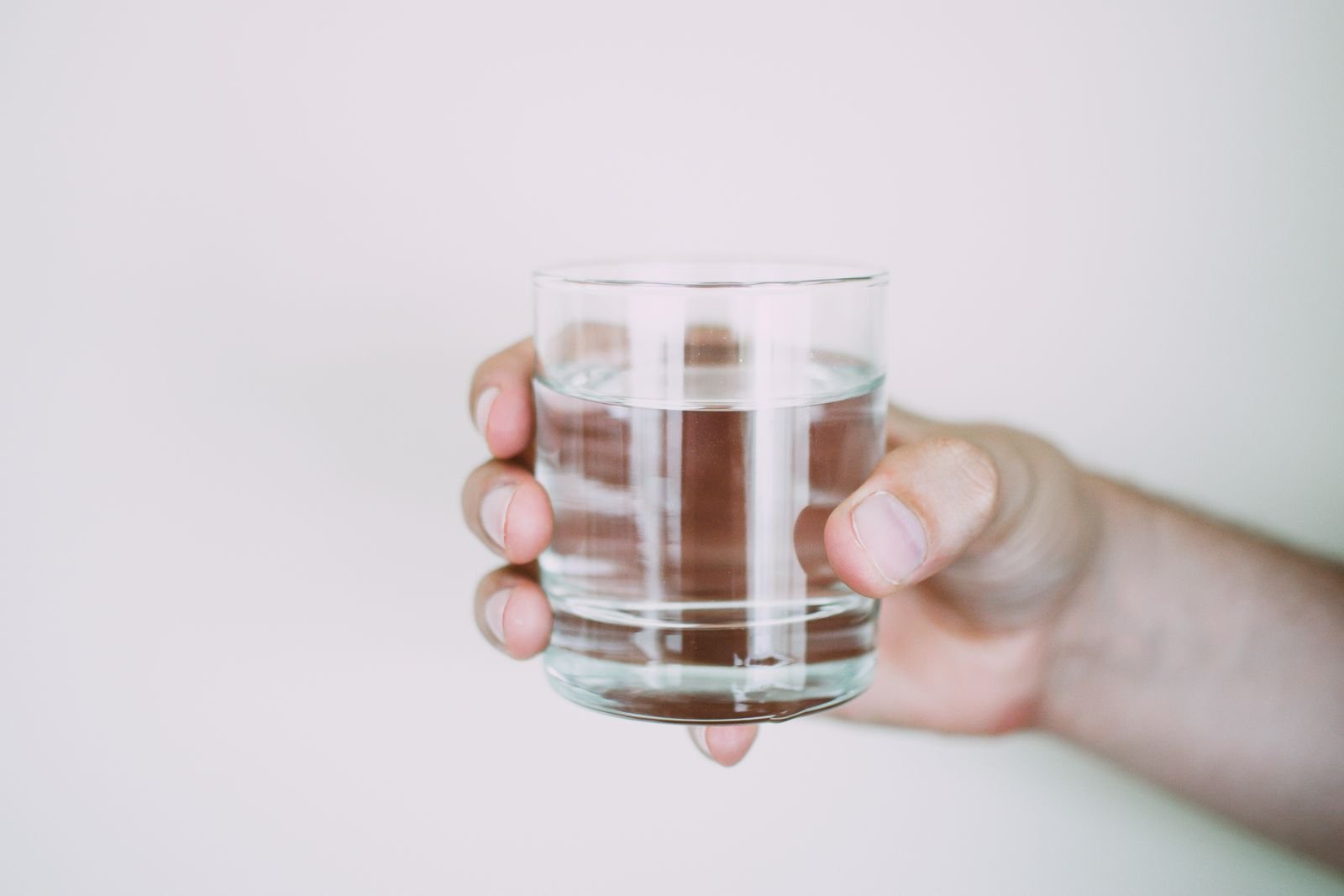 A hand holding a glass of water