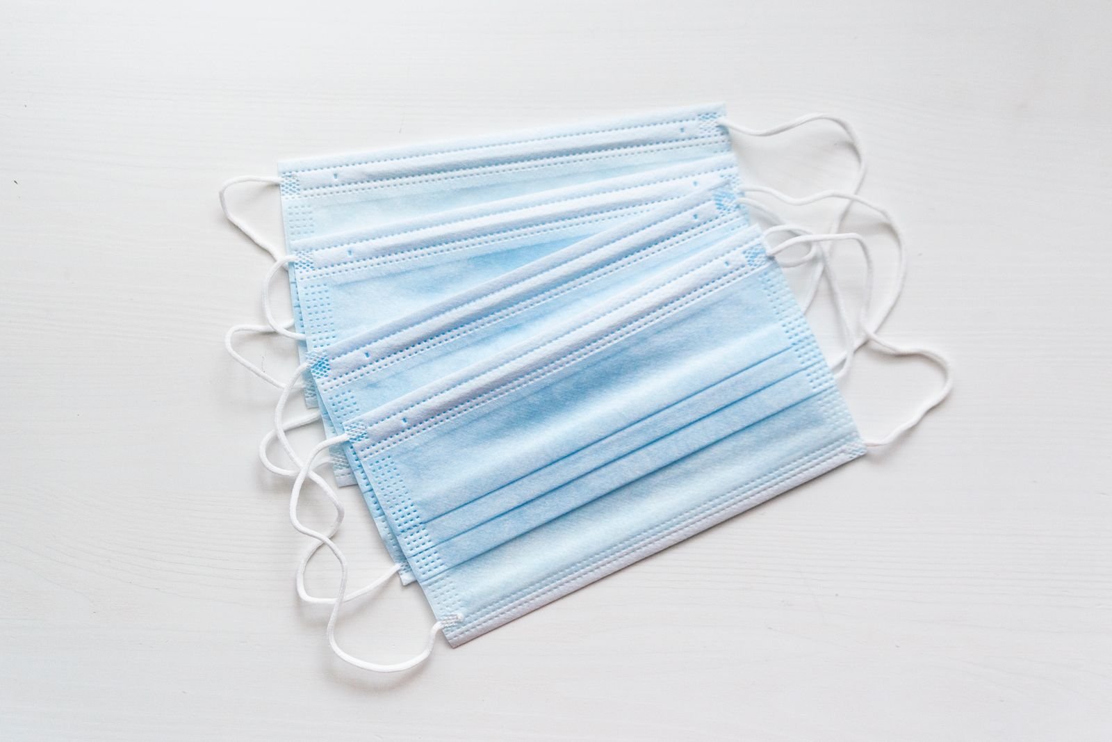 A pile of blue disposable surgical face masks